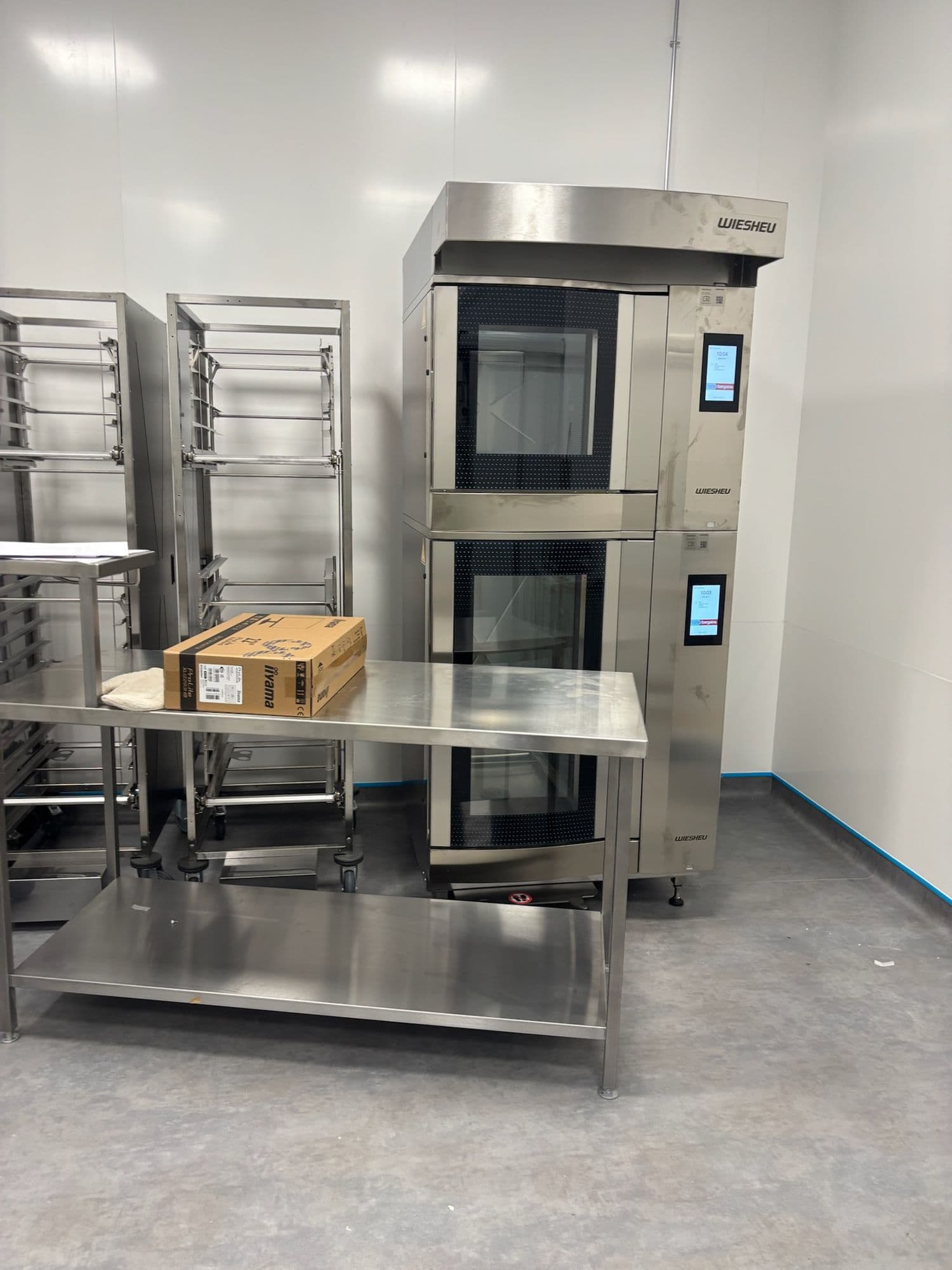 Commercial bakery kitchen with stainless steel tables and combination ovens
