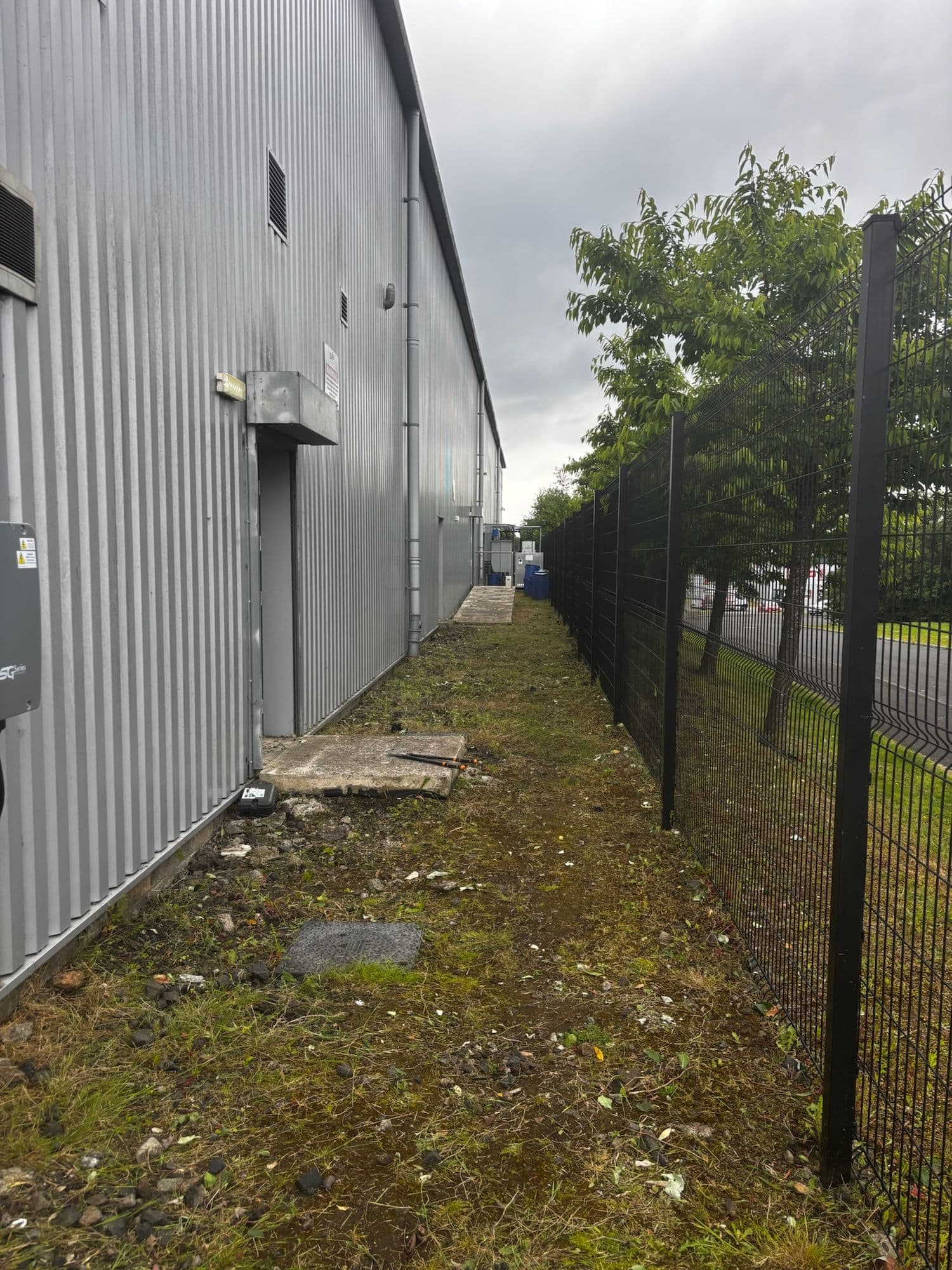 After: The verge beside the industrial unit cut back and cleared along the fence line