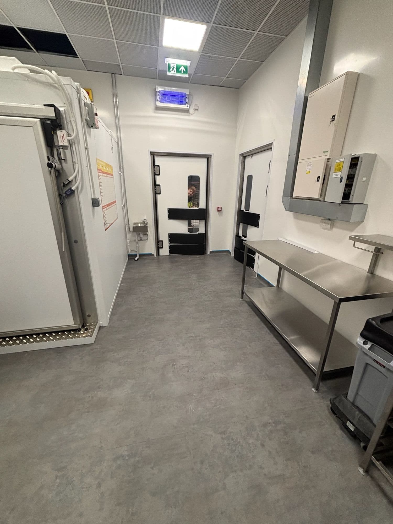 Back-of-house kitchen corridor with walk-in chiller and stainless benches