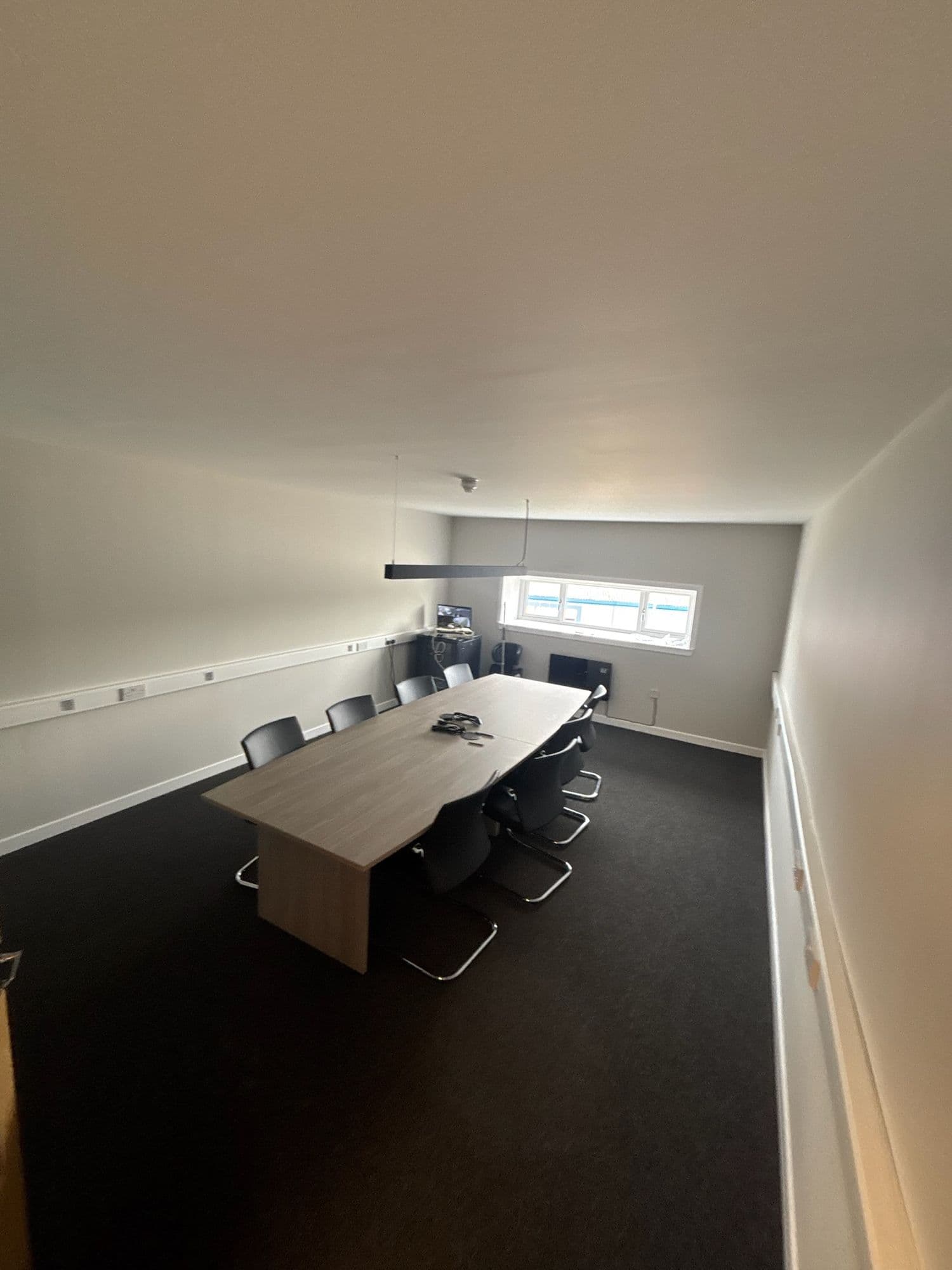 Boardroom with a long timber table and black chairs