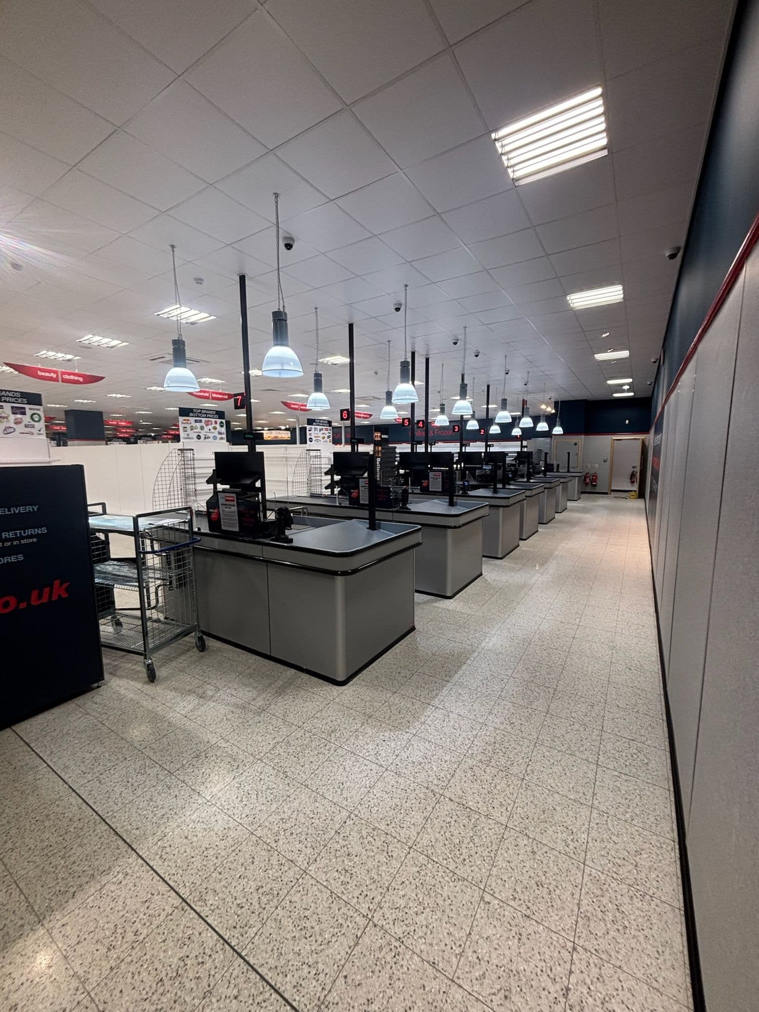 Row of new checkouts on a clean speckled floor in a store fit-out