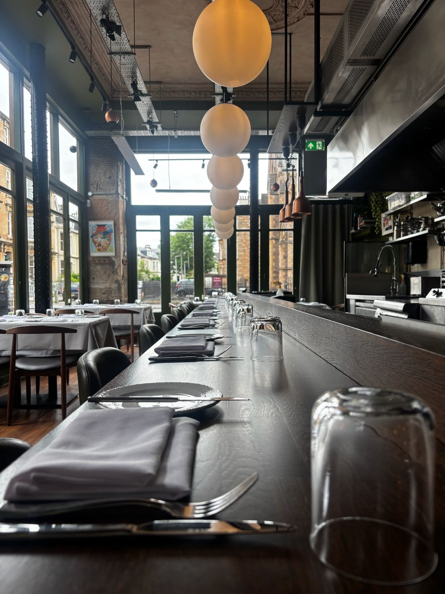 Dining tables laid with napkins and glassware in a bright restaurant
